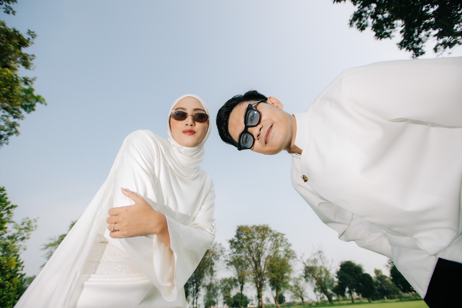 Stunning bride and groom posing elegantly in wedding attire indoors.